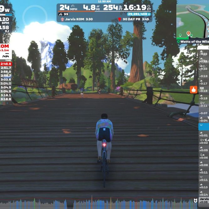 A cyclist is riding on a digital bridge in a virtual landscape with tall trees and mountains in the background. The screen displays performance metrics such as power (199W), speed (24 mph), distance (4.8 miles), and several leaderboard rankings for a competition called Jarvis KOM. The interface includes avatars of other cyclists nearby and a map of the route.