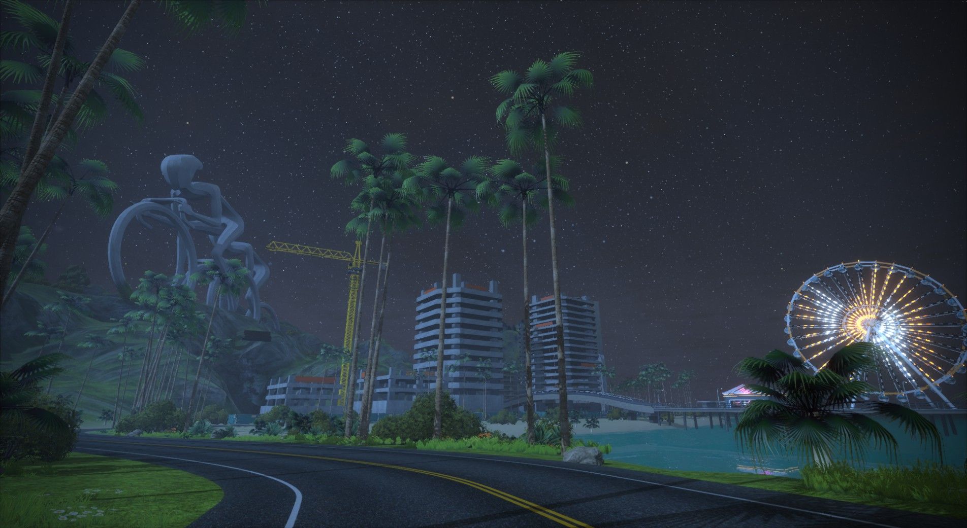 A nighttime scene in Zwift featuring a large bicycle sculpture, palm trees, and a brightly lit Ferris wheel. In the background, there are modern buildings under construction, along with a starry sky. The road curves through the landscape.