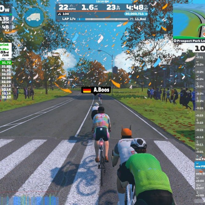 A digital cycling race scene from Zwift, showing three cyclists racing on a tree-lined road with autumn leaves. The screen displays rider statistics, including speed, distance, and power output, along with a leaderboard and map of the course.