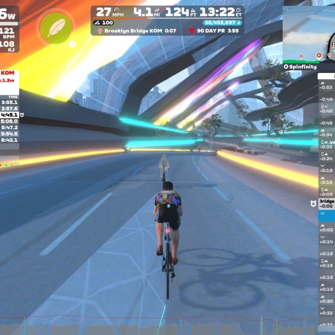 A cyclist rides on a digital road in Zwift, with colorful neon lights illuminating the space. The screen shows cycling stats, including power output, speed, and the cyclist's performance history on the Brooklyn Bridge segment. A list of nearby riders is displayed on the right side, indicating their power output and speeds. The virtual environment features futuristic elements and trees along the path.