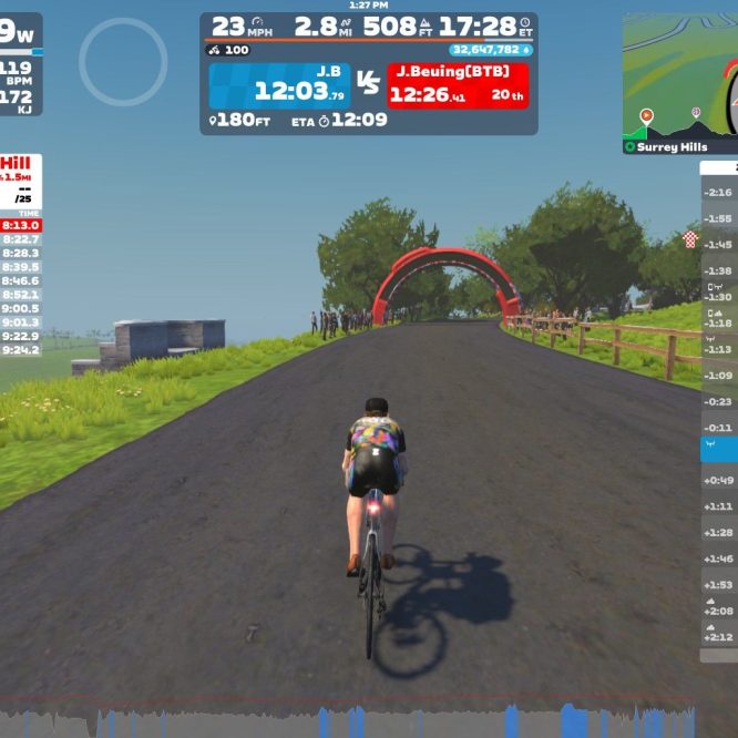 A cyclist rides on a virtual road in Zwift, with hills and trees in the background. The screen displays race statistics, including power output (209W), speed (23 mph), and a leaderboard with participant times and rankings. A red arch signifies a checkpoint. The interface shows nearby competitors and route details.