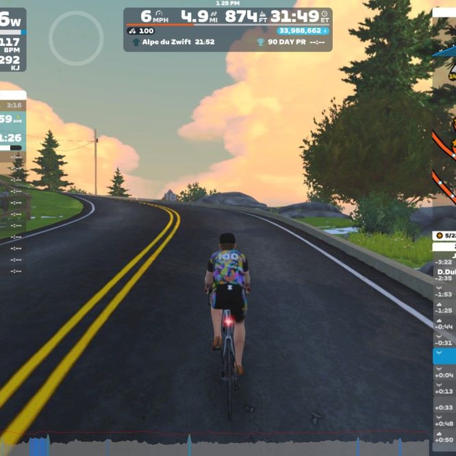 A cyclist is riding on a virtual road in Zwift, surrounded by trees and a colorful sky. The cyclist's avatar is wearing a colorful jersey, and the screen displays various statistics, including speed, distance, elevation, and heart rate. Roads curve ahead, leading up to a hilly terrain.